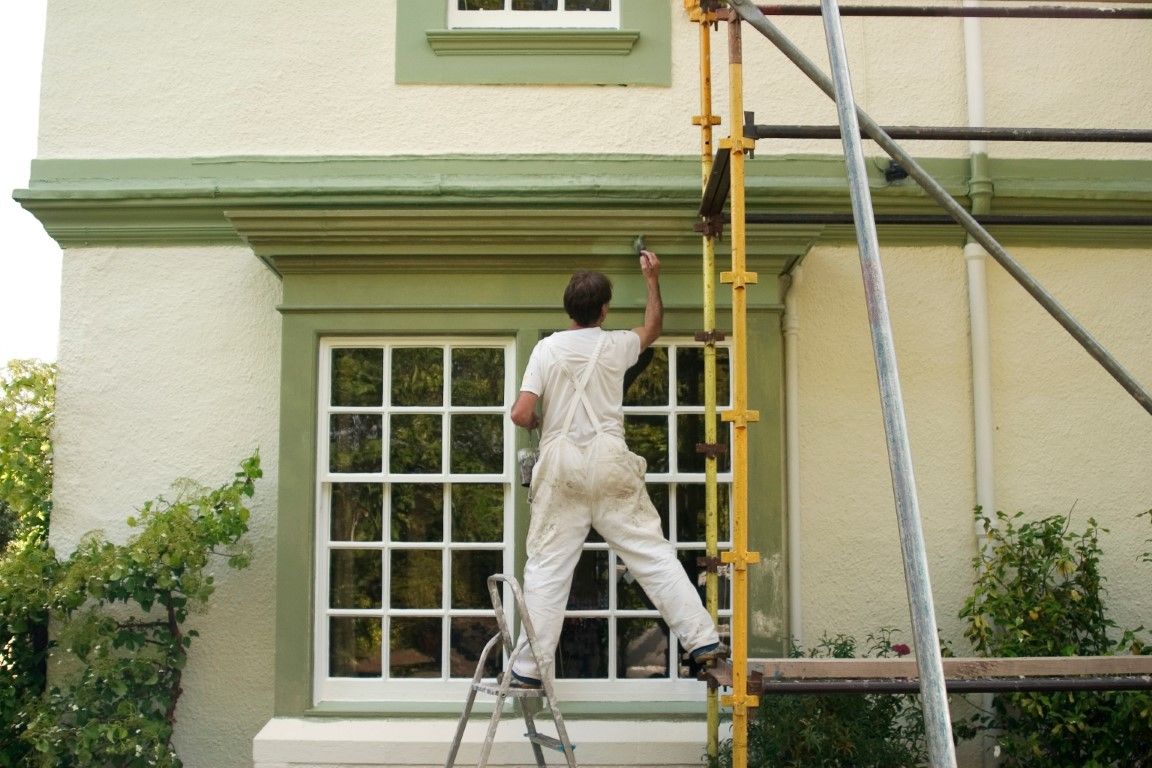 Painter applying an even finish coat to a home in Albany, GA