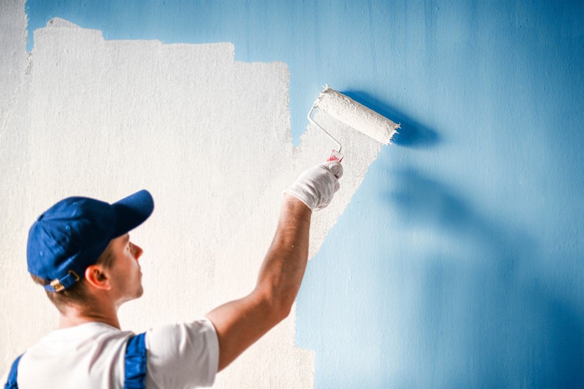 Painter cutting in a wall edge with a brush inside an Albany home